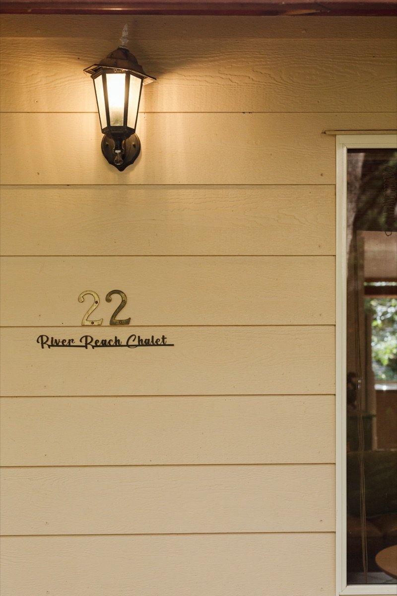 Number 22, River Reach Chalet — brass numerals beside a lantern at the entrance